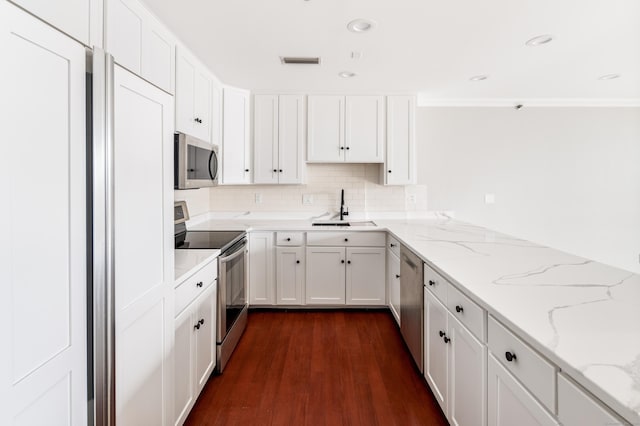 104 N St Apt 803, Stamford, CT 06902 - kitchen with appliances with stainless steel finishes, dark wood finished floors, tasteful backsplash, white cabinets, and light stone counters