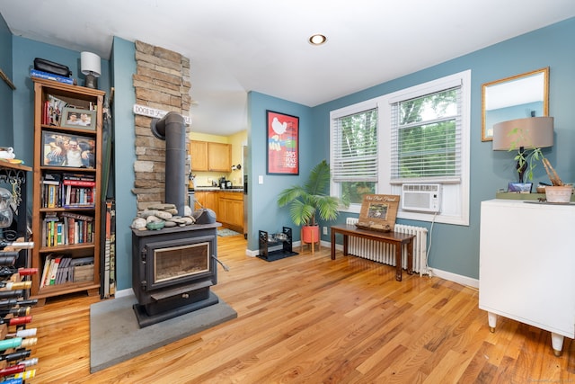610 S Elm St, Wallingford, CT 06492 - sitting room with a wood stove, radiator, light wood finished floors, and cooling unit