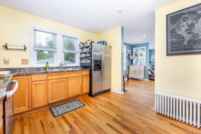 610 S Elm St, Wallingford, CT 06492 - kitchen with radiator, stainless steel appliances, light wood finished floors, brown cabinetry, and recessed lighting