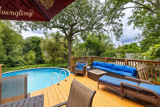 610 S Elm St, Wallingford, CT 06492 - swimming pool featuring an outdoor living space, a wooden deck, and view of scattered trees