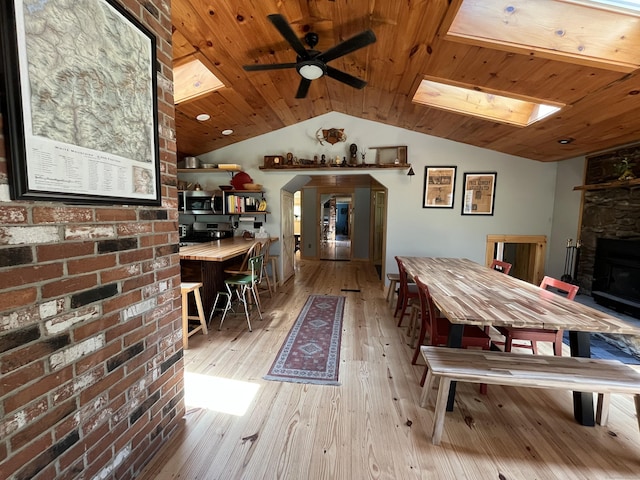 23 Little Bunggee Hill Rd, Woodstock, CT 06282 - dining space featuring ceiling fan, a skylight, light wood-style flooring, a fireplace, and wood ceiling