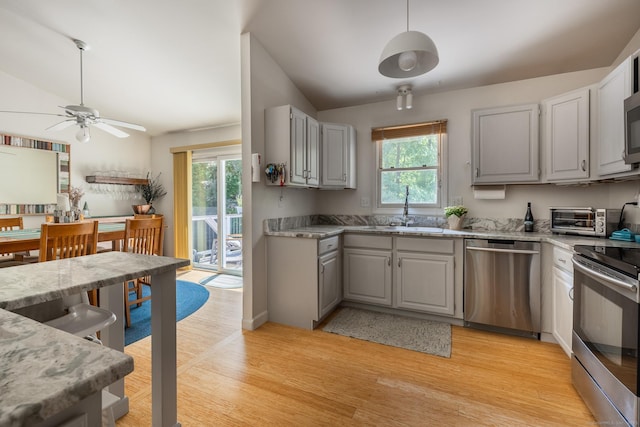 111 Nicole Dr, Milford, CT 06460 - kitchen featuring stainless steel appliances, healthy amount of natural light, gray cabinets, light wood-type flooring, and lofted ceiling