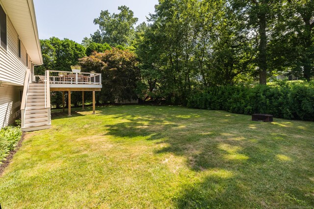 111 Nicole Dr, Milford, CT 06460 - view of grassy yard with stairway, a deck, and view of wooded area