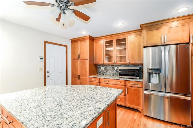 6 Big Buck Ln, Brookfield, CT 06804 - kitchen with stainless steel appliances, brown cabinetry, a ceiling fan, glass insert cabinets, and recessed lighting