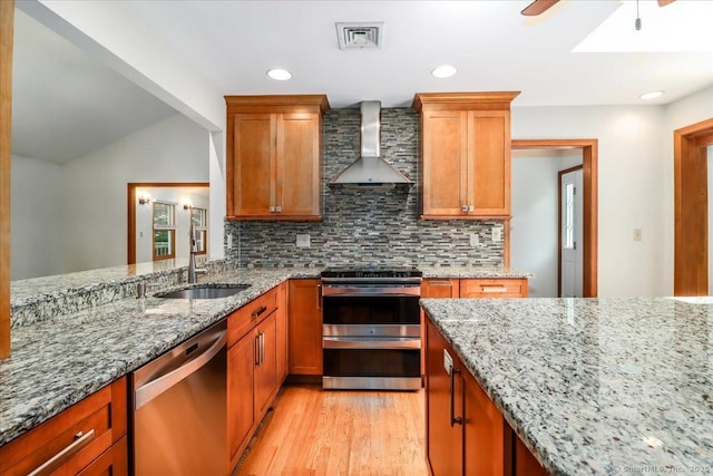 6 Big Buck Ln, Brookfield, CT 06804 - kitchen with appliances with stainless steel finishes, wall chimney range hood, decorative backsplash, light wood-style floors, and light stone counters