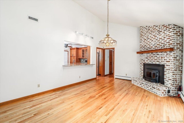 6 Big Buck Ln, Brookfield, CT 06804 - unfurnished living room featuring baseboard heating, high vaulted ceiling, wood-type flooring, a chandelier, and a wood stove