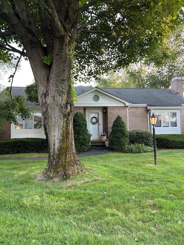 210 Jamestown Rd Unit 210, Stratford, CT 06614 - view of front of home featuring brick siding, a front yard, a chimney, and roof with shingles