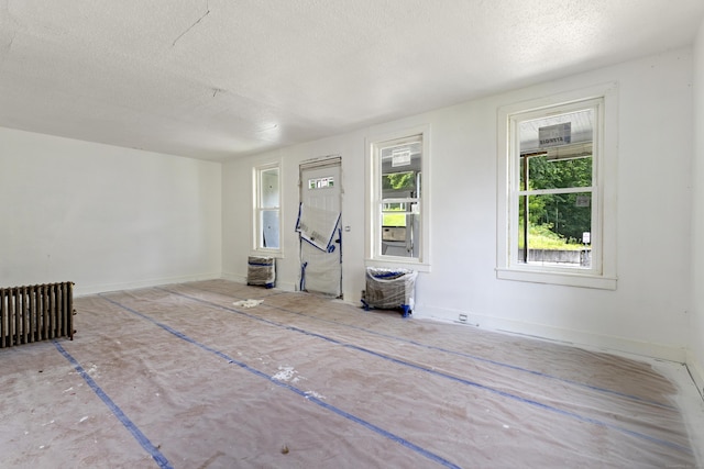 110 Franklin St, Killingly, CT 06239 - unfurnished living room featuring a textured ceiling and radiator