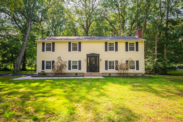 51 Brentley Dr, Shelton, CT 06484 - view of front of property with a chimney, a front yard, and view of scattered trees
