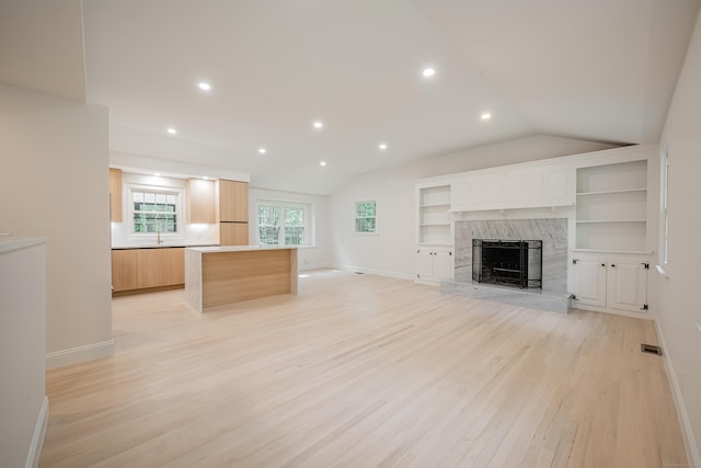 51 Brentley Dr, Shelton, CT 06484 - unfurnished living room featuring lofted ceiling, light wood finished floors, a fireplace, recessed lighting, and built in features