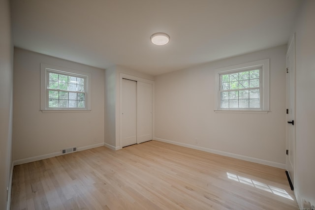 51 Brentley Dr, Shelton, CT 06484 - unfurnished bedroom featuring multiple windows, light wood finished floors, and a closet