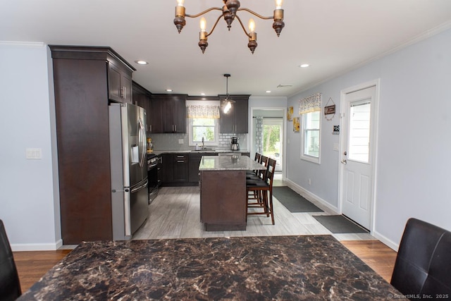 24 Dogwood Ln, Shelton, CT 06484 - kitchen featuring stainless steel fridge, a chandelier, ornamental molding, decorative backsplash, and light wood-style flooring