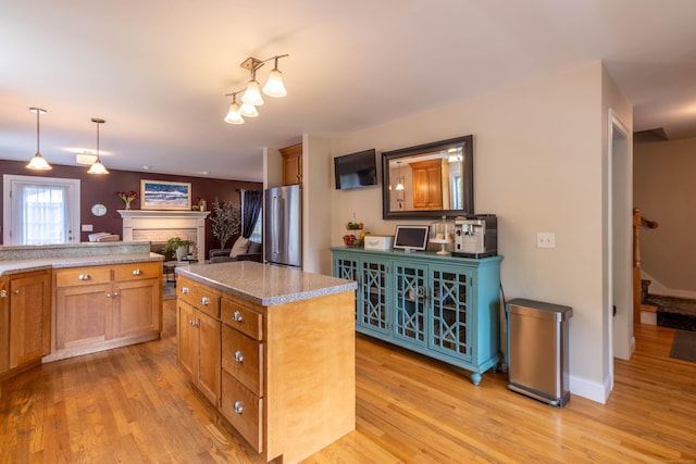 129 Clark Gates Rd, East Haddam, CT 06469 - kitchen featuring high end refrigerator, light wood finished floors, a fireplace, and a kitchen island