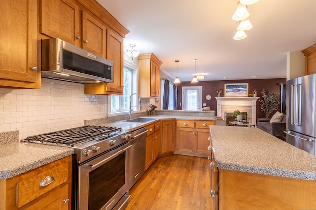 129 Clark Gates Rd, East Haddam, CT 06469 - kitchen featuring high quality appliances, brown cabinetry, light wood finished floors, and backsplash