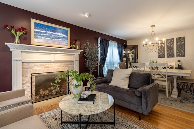 129 Clark Gates Rd, East Haddam, CT 06469 - living area with a brick fireplace, a chandelier, and wood finished floors