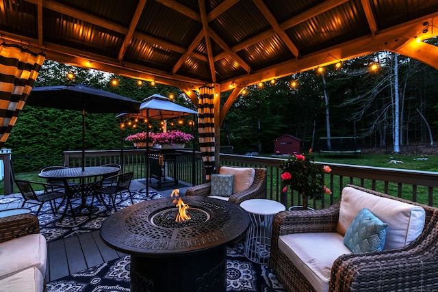129 Clark Gates Rd, East Haddam, CT 06469 - wooden terrace featuring a fire pit, a gazebo, a trampoline, a storage shed, and a lawn
