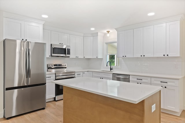 95 Great Ring Rd, Newtown, CT 06482 - kitchen with stainless steel appliances, light wood-style flooring, a kitchen island, white cabinetry, and recessed lighting