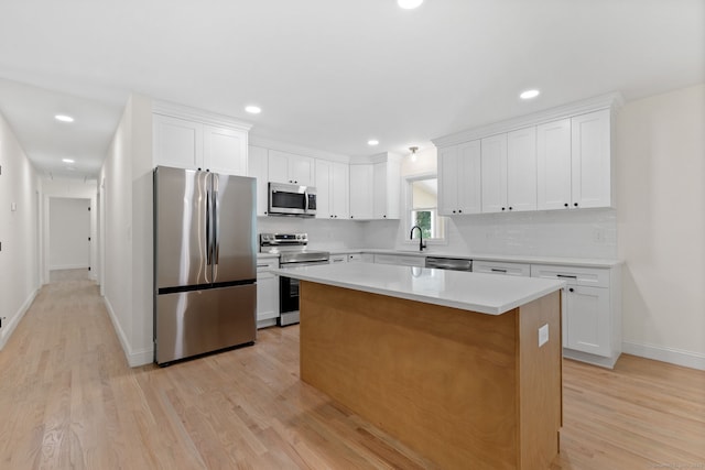 95 Great Ring Rd, Newtown, CT 06482 - kitchen featuring stainless steel appliances, a kitchen island, light wood finished floors, white cabinetry, and light countertops