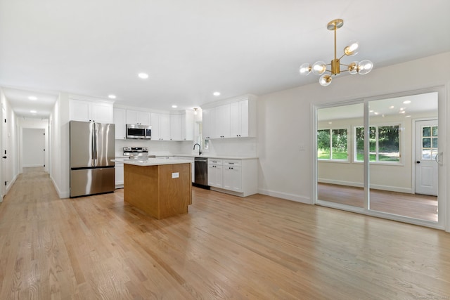 95 Great Ring Rd, Newtown, CT 06482 - kitchen featuring appliances with stainless steel finishes, a center island, light countertops, white cabinets, and light wood-style flooring