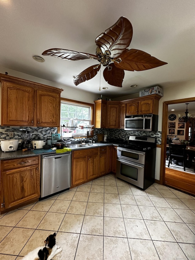 54 Carmel St, Hamden, CT 06518 - kitchen featuring stainless steel appliances, backsplash, a ceiling fan, light tile patterned flooring, and brown cabinetry