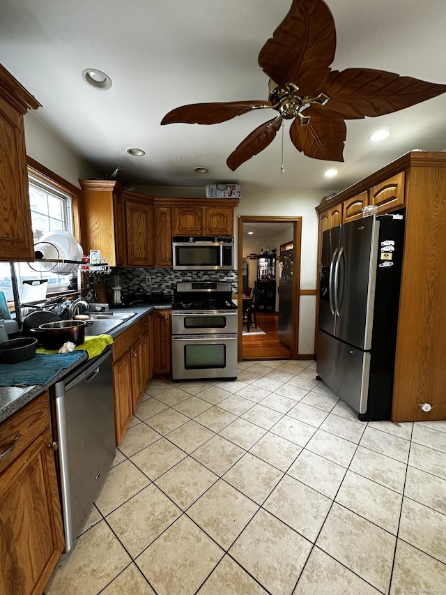 54 Carmel St, Hamden, CT 06518 - kitchen featuring stainless steel appliances, light tile patterned flooring, backsplash, dark countertops, and recessed lighting