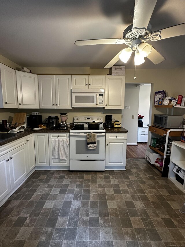 54 Carmel St, Hamden, CT 06518 - kitchen with white appliances, dark countertops, a ceiling fan, and white cabinetry