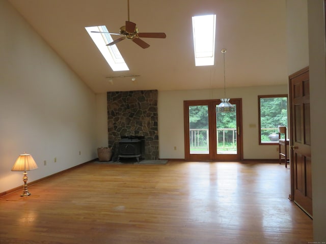 1200 Peck Ln, Cheshire, CT 06410 - unfurnished living room featuring a skylight, high vaulted ceiling, a wood stove, light wood-style flooring, and a ceiling fan