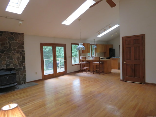 1200 Peck Ln, Cheshire, CT 06410 - living area featuring a skylight, a wood stove, light wood finished floors, track lighting, and high vaulted ceiling