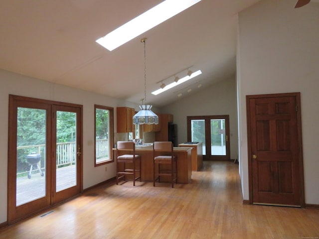 1200 Peck Ln, Cheshire, CT 06410 - kitchen featuring a skylight, vaulted ceiling, a peninsula, light wood-style flooring, and french doors