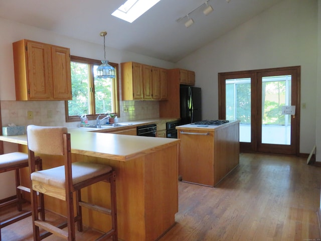 1200 Peck Ln, Cheshire, CT 06410 - kitchen featuring black appliances, lofted ceiling, a center island, tasteful backsplash, and light countertops