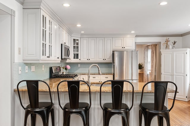 41 Arlington Rd, Stamford, CT 06902 - kitchen with appliances with stainless steel finishes, a peninsula, light stone counters, glass insert cabinets, and tasteful backsplash