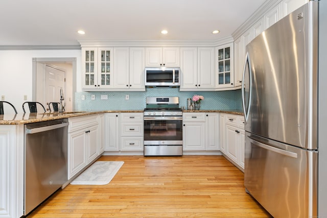 41 Arlington Rd, Stamford, CT 06902 - kitchen with stainless steel appliances, light wood finished floors, white cabinets, light stone counters, and recessed lighting