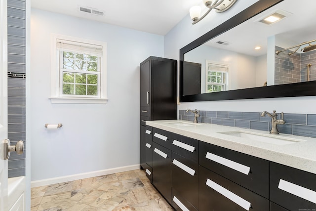 41 Arlington Rd, Stamford, CT 06902 - bathroom featuring double vanity, healthy amount of natural light, marble look tile flooring, and a shower