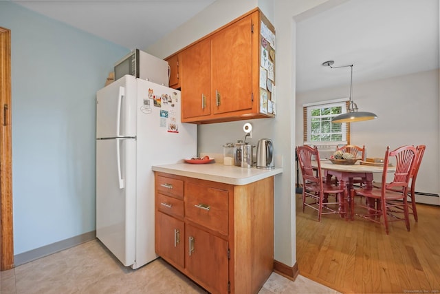 6 Fern St, Norwalk, CT 06854 - kitchen featuring freestanding refrigerator, brown cabinetry, light countertops, and pendant lighting