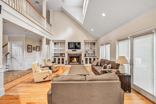 28 Aldo Dr, Woodbridge, CT 06525 - living area featuring high vaulted ceiling, a lit fireplace, a wainscoted wall, light wood finished floors, and crown molding