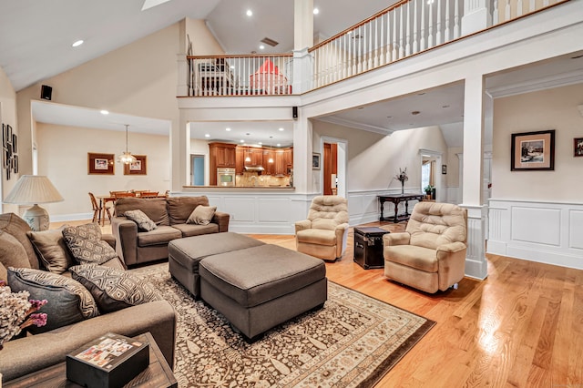 28 Aldo Dr, Woodbridge, CT 06525 - living area with light wood finished floors, high vaulted ceiling, wainscoting, a decorative wall, and a skylight