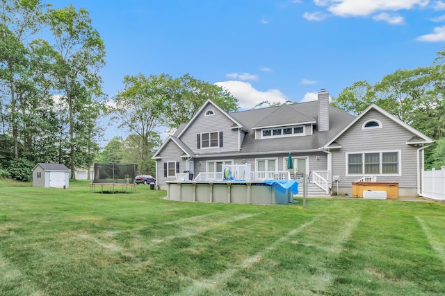 28 Aldo Dr, Woodbridge, CT 06525 - back of house with a shed, a covered hot tub, a trampoline, an outdoor pool, and a chimney