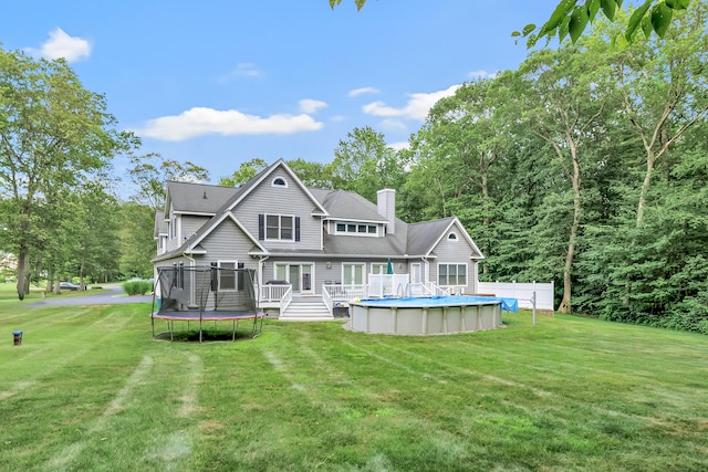 28 Aldo Dr, Woodbridge, CT 06525 - back of property with a trampoline, a deck, an outdoor pool, and a yard