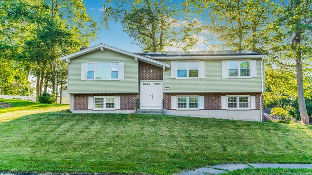 151 Stevenson Rd, Meriden, CT 06451 - bi-level home featuring brick siding, a front lawn, and roof mounted solar panels