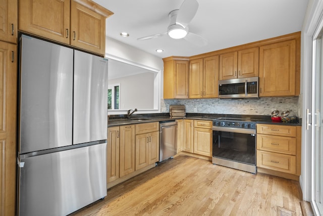 518 Iroquois Ln Unit A, Stratford, CT 06614 - kitchen featuring appliances with stainless steel finishes, dark countertops, light wood-type flooring, a ceiling fan, and backsplash