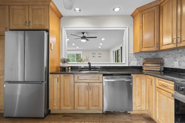 518 Iroquois Ln Unit A, Stratford, CT 06614 - kitchen with appliances with stainless steel finishes, a ceiling fan, dark wood-style floors, backsplash, and dark stone countertops