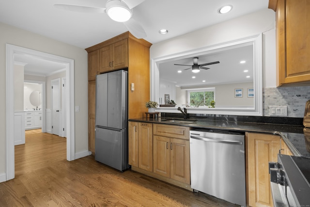 518 Iroquois Ln Unit A, Stratford, CT 06614 - kitchen with stainless steel appliances, ceiling fan, wood finished floors, backsplash, and brown cabinetry