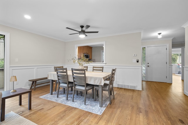 518 Iroquois Ln Unit A, Stratford, CT 06614 - dining room featuring a ceiling fan, crown molding, light wood-style flooring, a decorative wall, and wainscoting