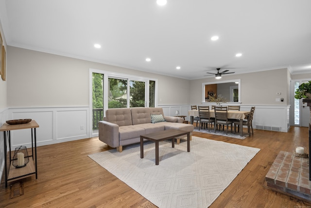 518 Iroquois Ln Unit A, Stratford, CT 06614 - living room with crown molding, a decorative wall, a ceiling fan, a wainscoted wall, and wood finished floors