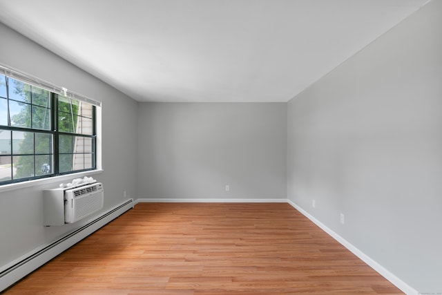 37 Enid St Apt C, Bridgeport, CT 06606 - unfurnished room with a baseboard heating unit, light wood-style flooring, and an AC wall unit