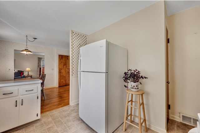 33 Hazel Ave, Naugatuck, CT 06770 - kitchen with freestanding refrigerator, white cabinetry, hanging light fixtures, and light countertops