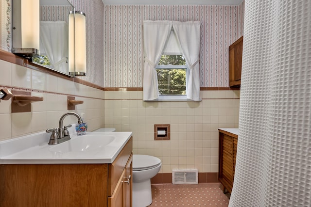33 Hazel Ave, Naugatuck, CT 06770 - bathroom featuring wallpapered walls, vanity, a wainscoted wall, tile walls, and tile patterned floors