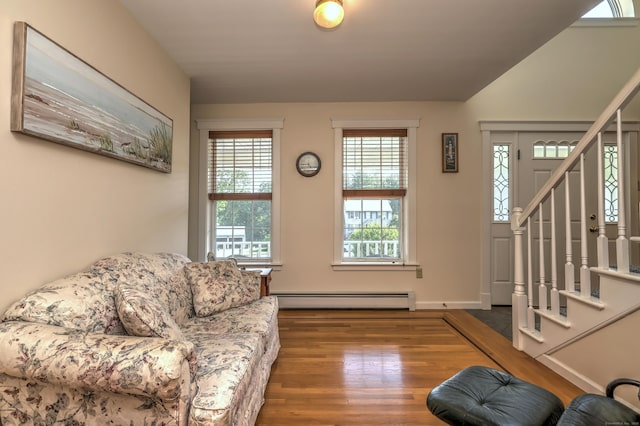 67 Nicole Dr, Naugatuck, CT 06770 - living area with baseboard heating, wood finished floors, stairs, and lofted ceiling