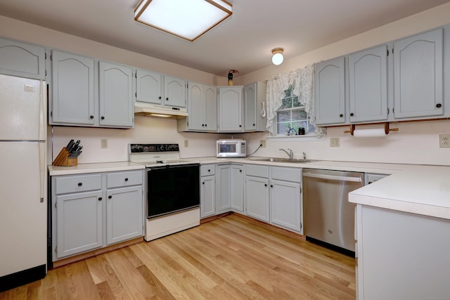 67 Nicole Dr, Naugatuck, CT 06770 - kitchen with white appliances, under cabinet range hood, light wood finished floors, and light countertops