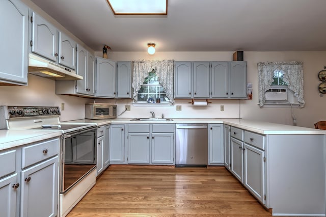 67 Nicole Dr, Naugatuck, CT 06770 - kitchen with stainless steel appliances, under cabinet range hood, a peninsula, gray cabinetry, and light countertops